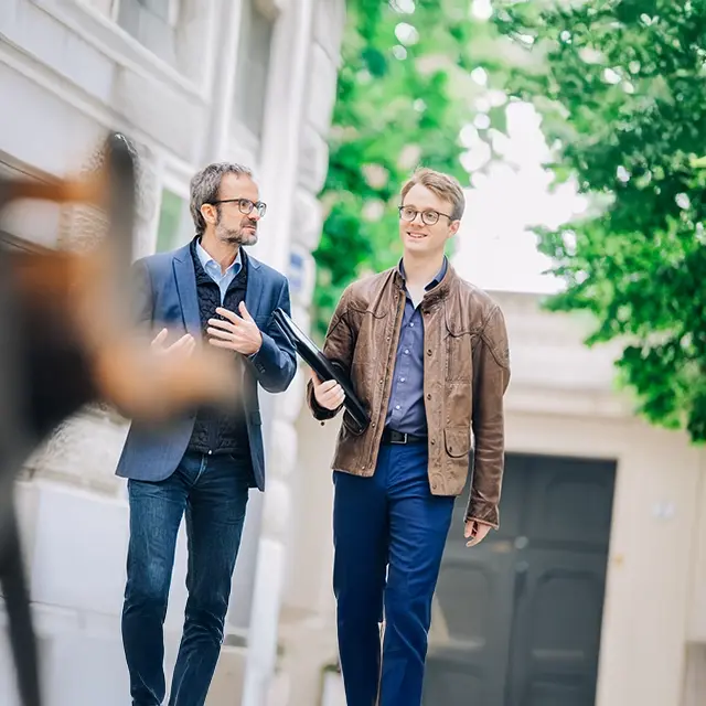 Stefan Schiel und Jan-Michael Bussmann unterhalten sich, auf dem Weg zum Kundenmeeting. Zwischen den beiden herrscht eine lebendige und freundliche Gesprächsatmosphäre.