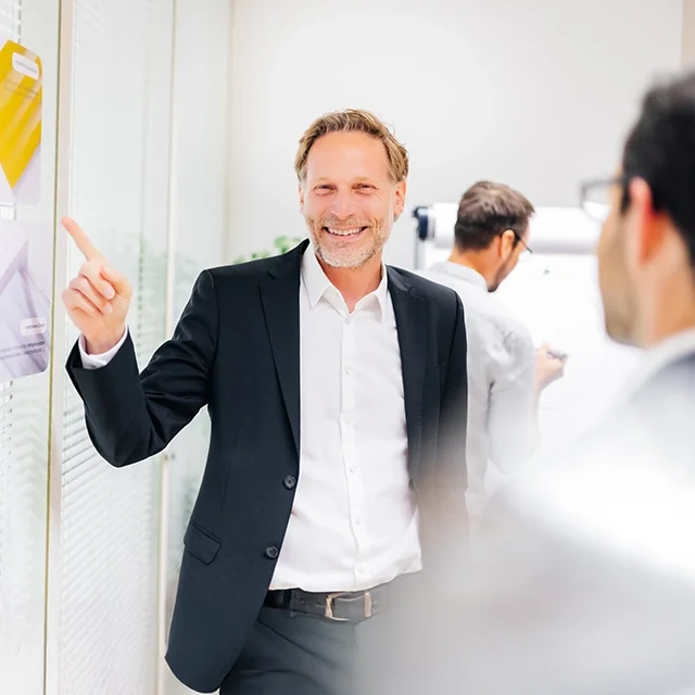 Thomas Winder in angeregter aber lockerer Diskussion mit Kollegen während eines Workshops.