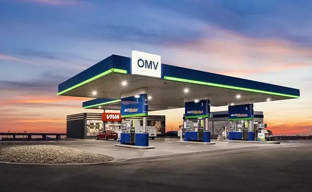 OMV-Tankstelle mit VIVA-Shop bei Sonnenuntergang.