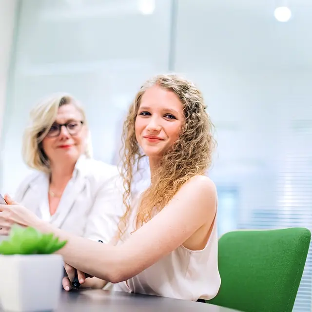 Sophie Buchta sitzt in einem Besprechungszimmer im markemtind Büro und wird dabei von Britta Veser bei ihrer Arbeit unterstützt.