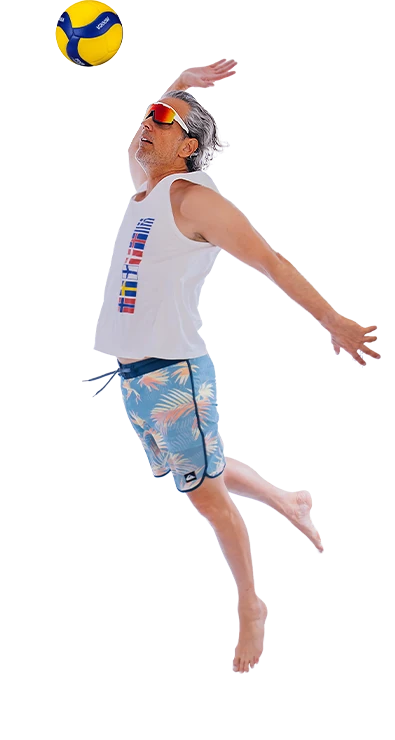 Erik Stadler springt dynamisch in die Luft und schlägt einen Volleyball über das Netz - sportlich, energiegeladen und voller Sommer-Feeling.