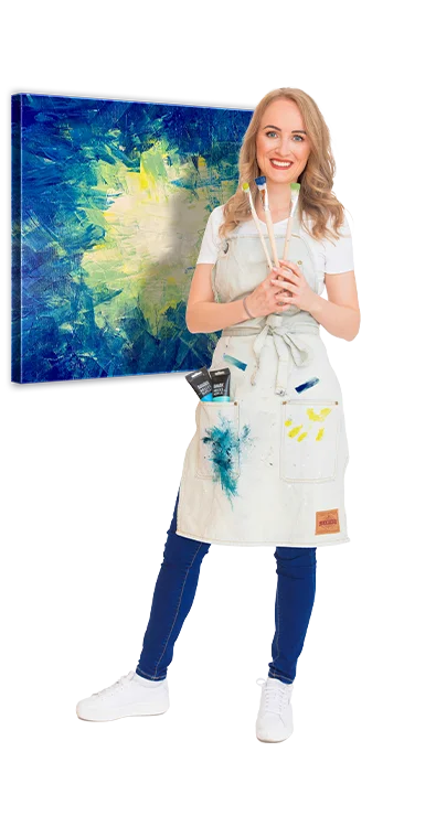 Ricarda Carina Rainer trägt eine Malerschürze mit Farbflecken, hält Pinsel und Farbe, im Hintergrund ein abstraktes, farbenfrohes Kunstwerk - kreativ, künstlerisch und ausdrucksstark.